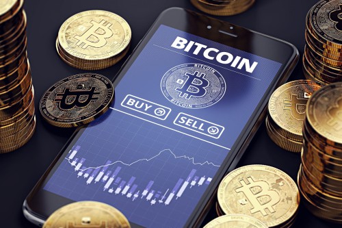 Смартфон и монеты Биткоин