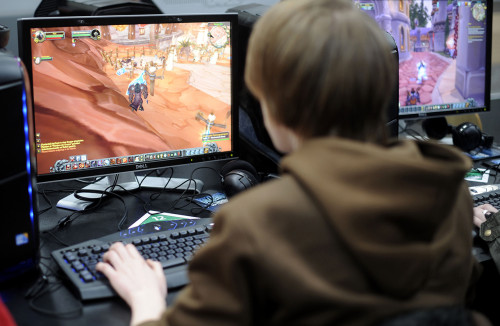Молодой человек играет в игру на компьютере